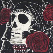 Photo of linocut Santa Muerta, showing large white skull draped with black cloth and surranded by red roses.