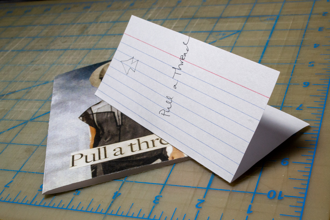 Behind the scenes: Pull a Thread. An un-sewn copy of Pull a Thread with a hole punch jig on top.